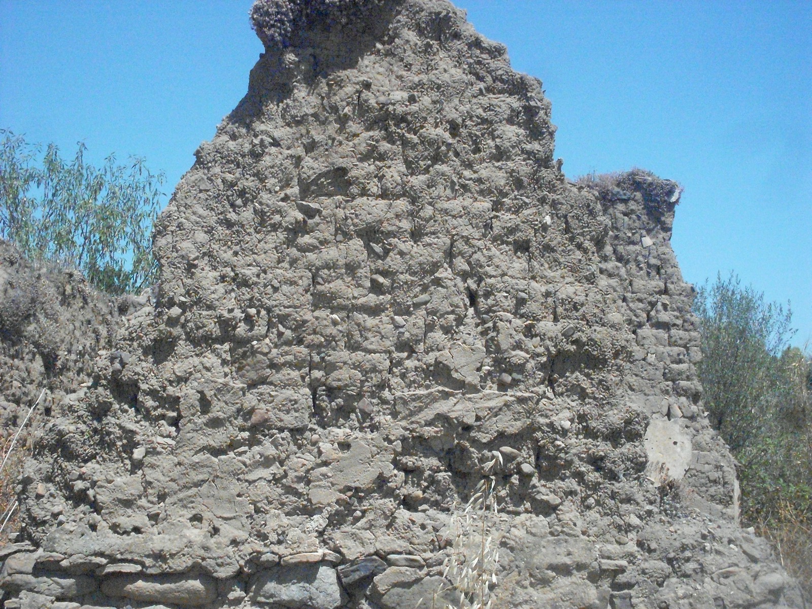 Mauer aus traditionellen sardischen Lehmziegeln (ladiri) auf einem Steinsockel, ein Beispiel der Terra-cruda-Bautradition Sardiniens.