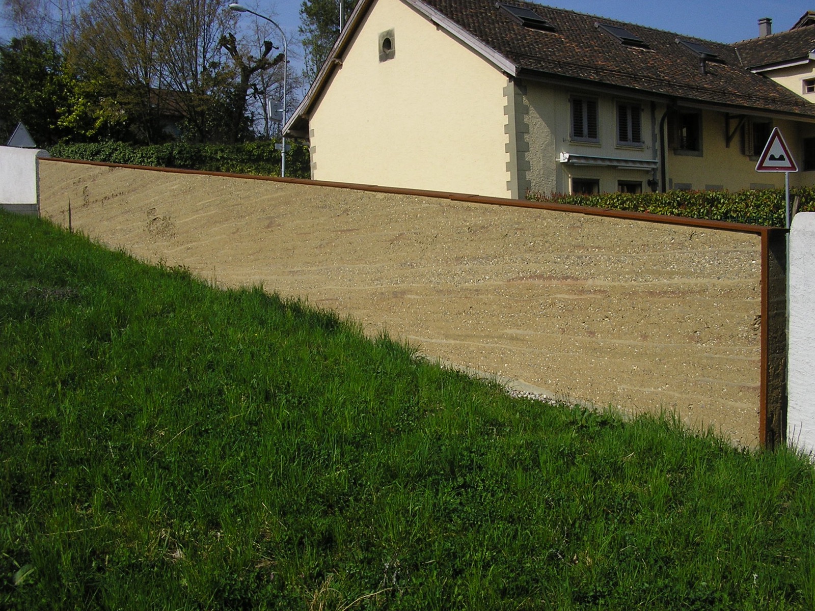 Stampflehmwand am Gemeindehaus von Confignon im Kanton Genf, Schweiz, ausgefuehrt 2007 von Martin Rauch; sichtbare horizontale Schichtungen des verdichteten Lehms.