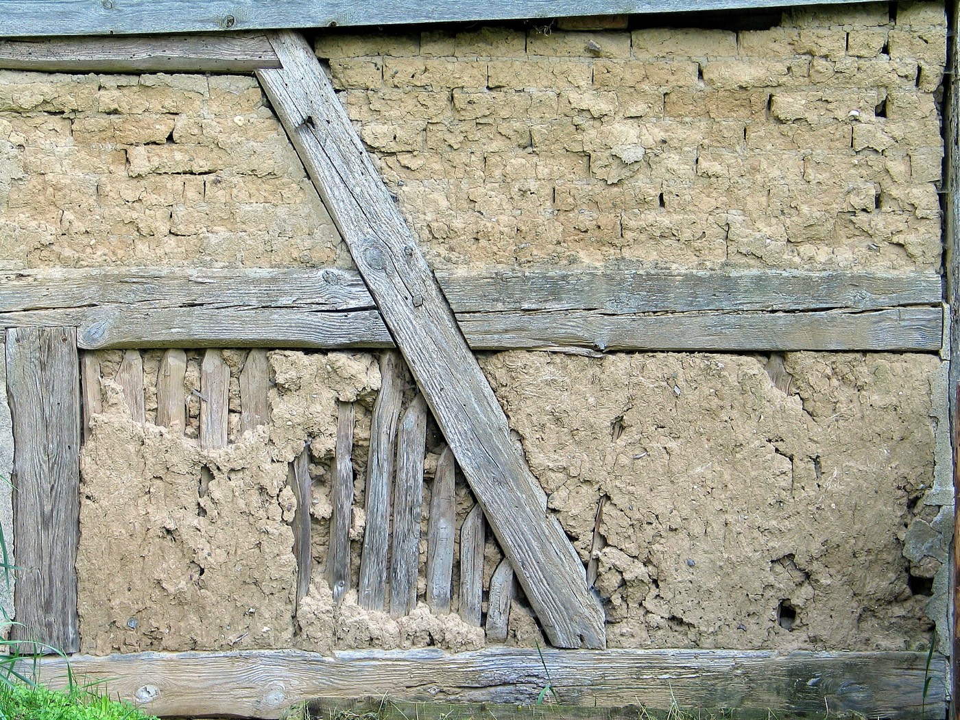 Fachwerkwand mit Lehmausfachung – oben Lehmsteine, unten Staken