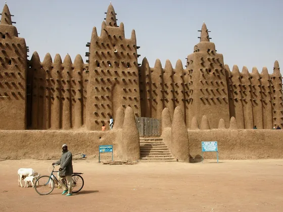 Die Große Moschee von Djenné in Mali, ein Lehmbau mit vorstehenden Palmholzstangen in der Fassade